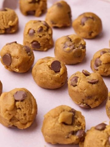 Balls of cookie dough on a baking sheet ready to be frozen.