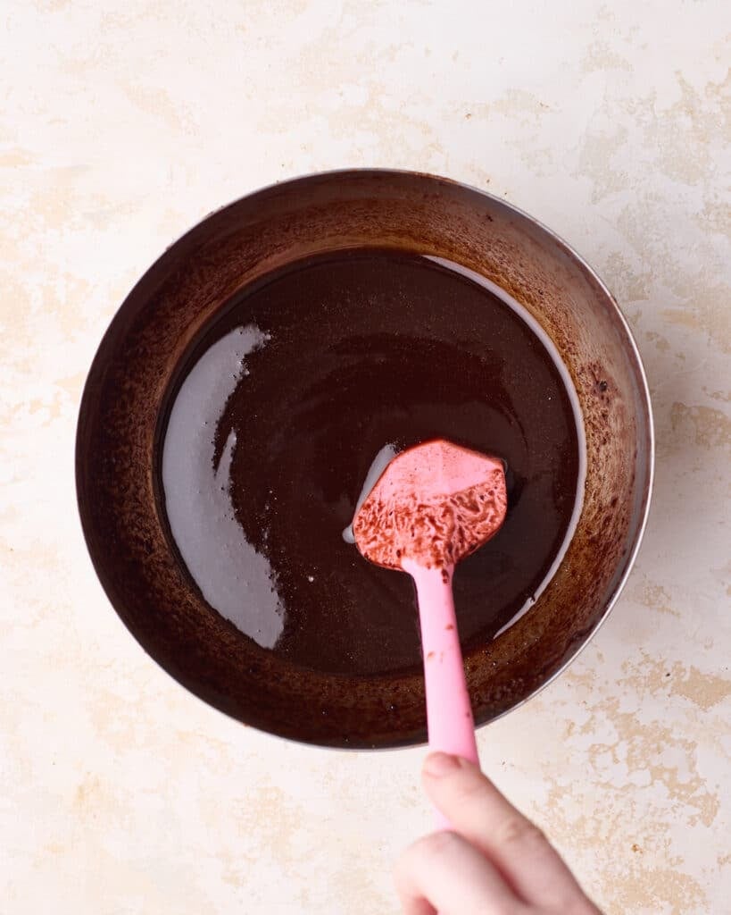 Melted chocolate mixture being stirred in a bowl.
