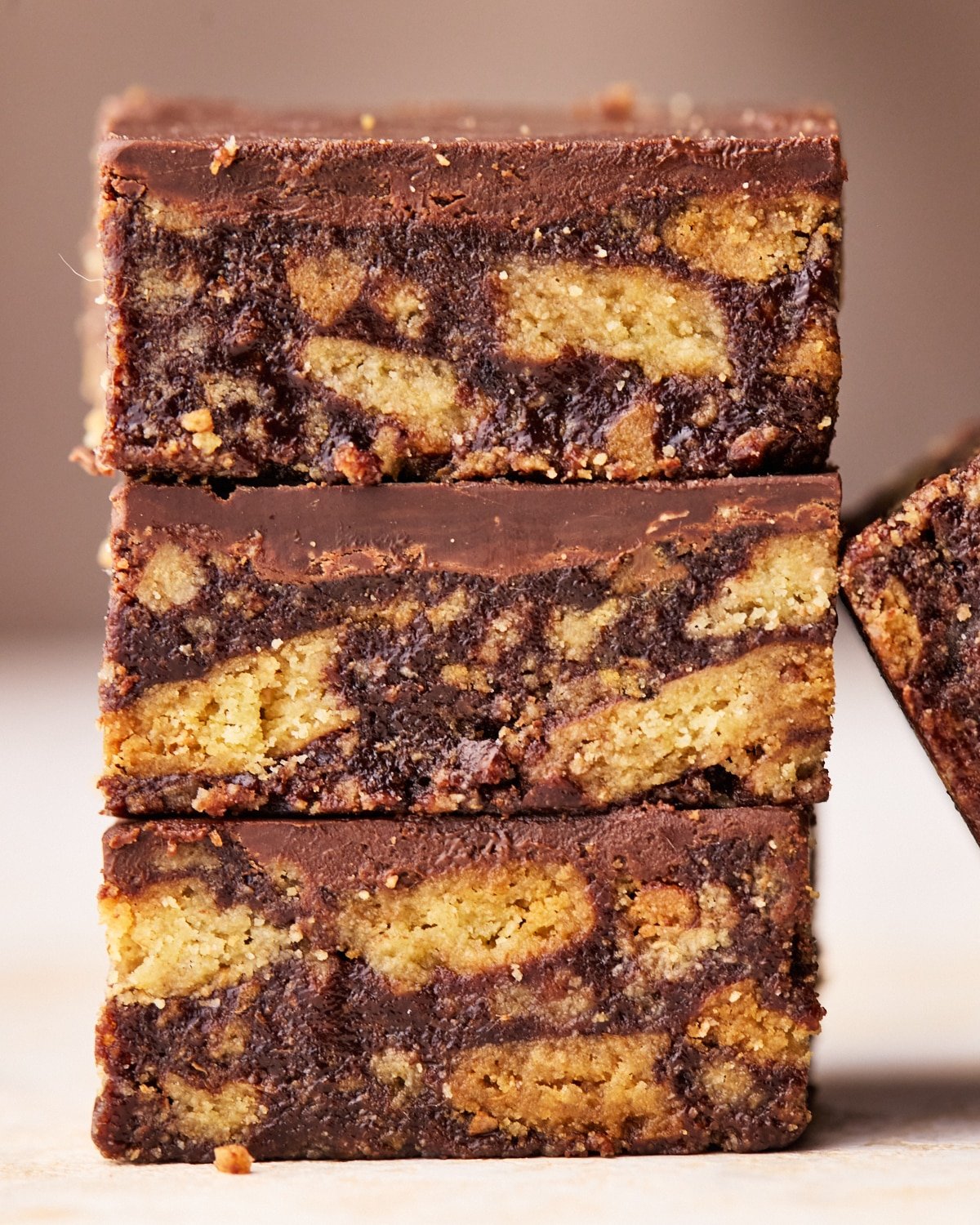 Close up of a stack of tiffin, three squares of chocolate biscuit traybake.