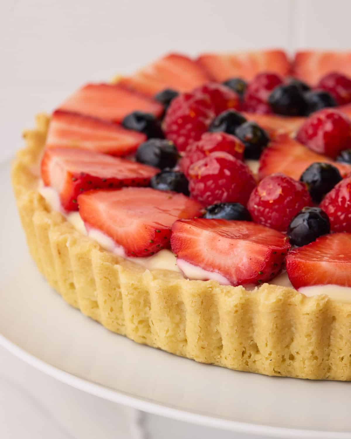 Fresh fruit tart from the side to show a close-up of the buttery shortbread crust.