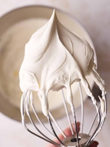 Perfect whipped cream on a whisk with stiff peaks.