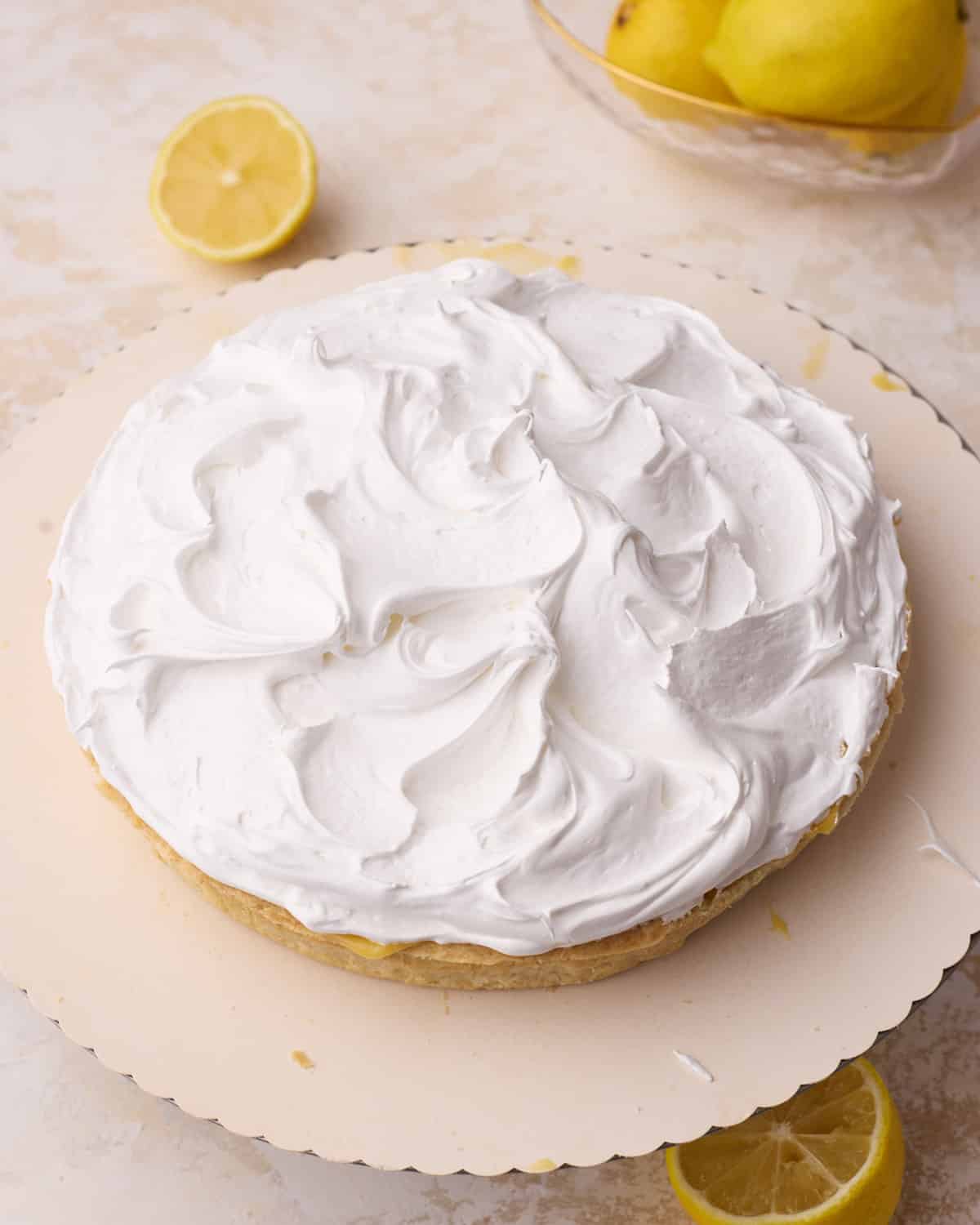 Swiss meringue on top of lemon filling in a pie crust to make lemon meringue pie - before toasting.