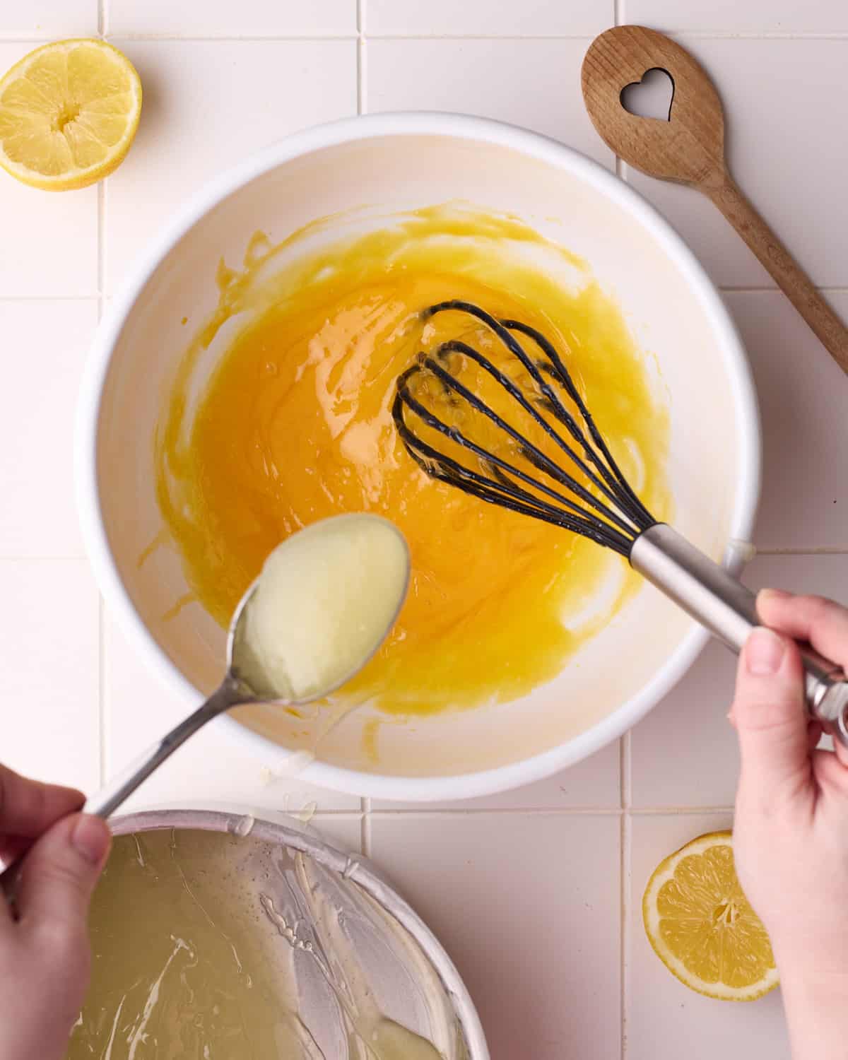 Adding a spoonful of hot lemon filling into whisked egg yolks to temper the eggs gradually for lemon meringue pie.