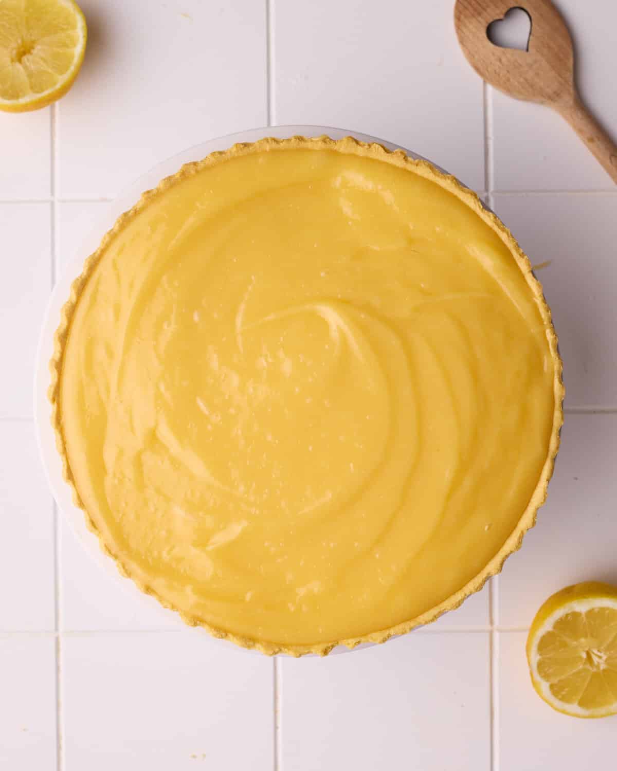Lemon filling inside a shortcrust pie crust, ready to be chilled.