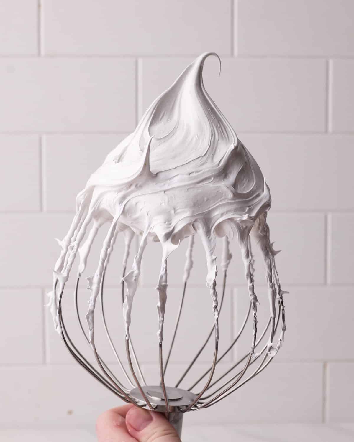 meringue whipped to firm peaks on a stand mixer whisk.